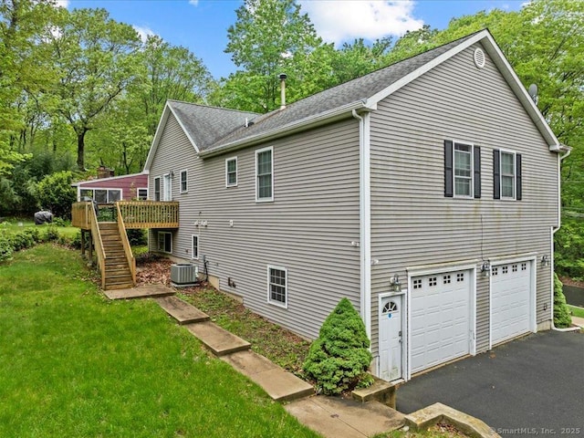 126 Conrad Dr, New Haven, CT 06515 - view of side of property with stairway, an attached garage, a wooden deck, asphalt driveway, and a yard
