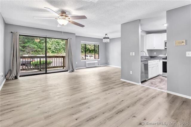 175 Mill Pond Rd Unit 203, Hamden, CT 06514 - unfurnished living room featuring a ceiling fan, light wood-style floors, a textured ceiling, a wall mounted air conditioner, and a chandelier