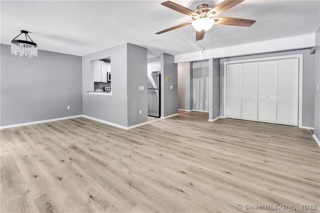 175 Mill Pond Rd Unit 203, Hamden, CT 06514 - unfurnished living room with a chandelier, ceiling fan, and wood finished floors