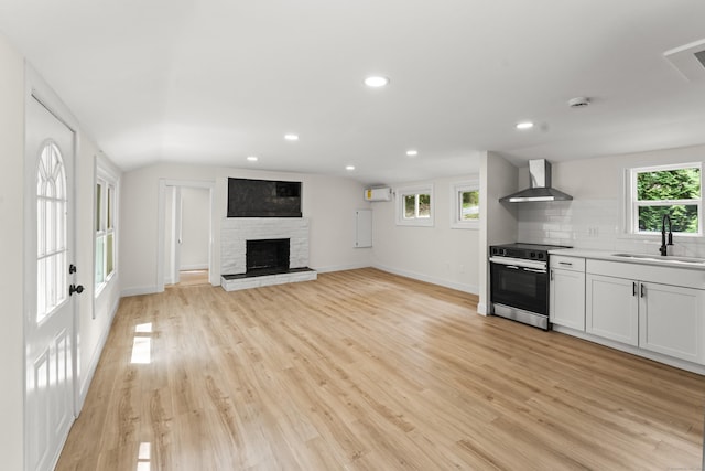 40 Clearview Rd, East Haddam, CT 06469 - kitchen featuring electric stove, wall chimney range hood, a wall mounted AC, tasteful backsplash, and light wood-style floors