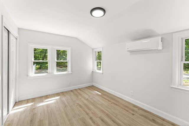 40 Clearview Rd, East Haddam, CT 06469 - unfurnished bedroom with a wall mounted air conditioner, light wood-type flooring, vaulted ceiling, multiple windows, and a closet