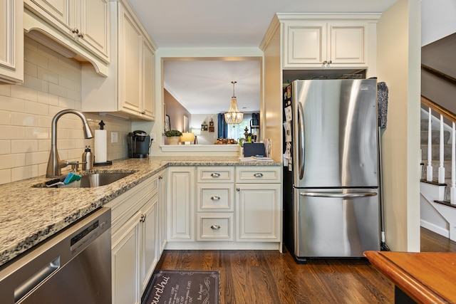 250 Summer St Unit 29, Southington, CT 06479 - kitchen featuring appliances with stainless steel finishes, dark wood-style flooring, decorative backsplash, light stone countertops, and a chandelier