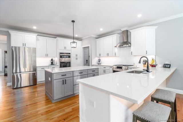 11 Tall Oaks Dr Unit 11, New Milford, CT 06776 - kitchen featuring stainless steel appliances, wall chimney exhaust hood, ornamental molding, gray cabinetry, and a kitchen breakfast bar