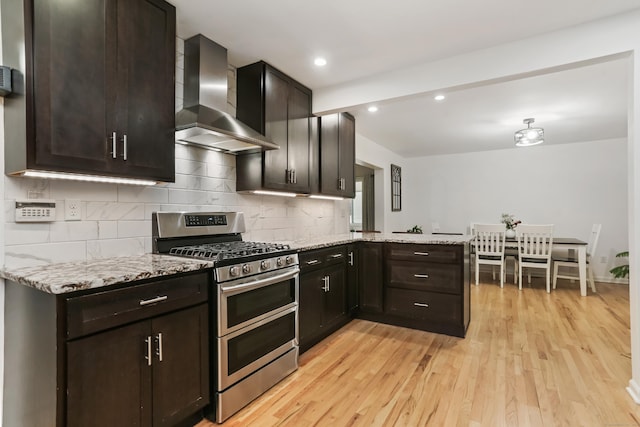 11 Park Ln, Trumbull, CT 06611 - kitchen featuring wall chimney exhaust hood, double oven range, a peninsula, light wood finished floors, and light stone counters