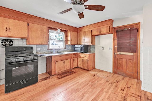 70 Sage Ave, Bridgeport, CT 06610 - kitchen with black appliances, light countertops, light wood-type flooring, and a ceiling fan