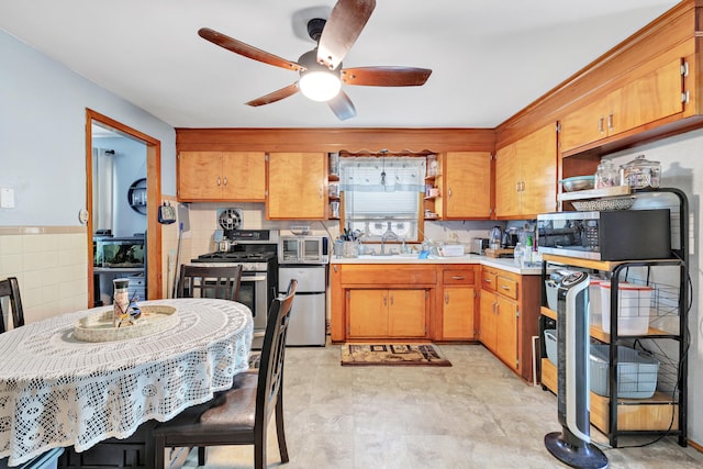 70 Sage Ave, Bridgeport, CT 06610 - kitchen featuring appliances with stainless steel finishes, a ceiling fan, light countertops, open shelves, and brown cabinets