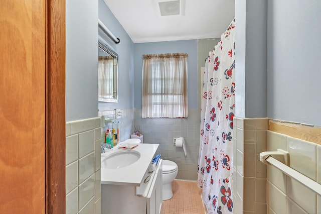 70 Sage Ave, Bridgeport, CT 06610 - full bath featuring tile walls, vanity, tile patterned flooring, a wainscoted wall, and a shower with shower curtain