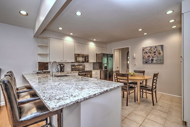 23 Fox Rd, Trumbull, CT 06611 - kitchen featuring black appliances, open shelves, recessed lighting, a peninsula, and a breakfast bar