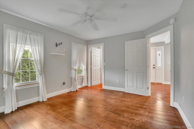 185 Chimney Hill Rd, Wallingford, CT 06492 - unfurnished bedroom with multiple windows, wood finished floors, and a ceiling fan