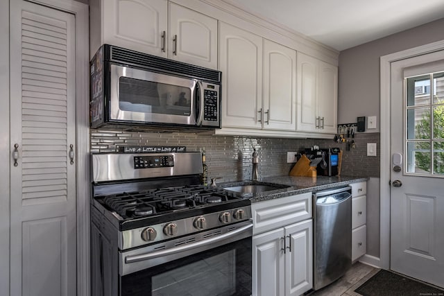 33 Thorpe St, North Haven, CT 06473 - kitchen with stainless steel appliances, white cabinetry, backsplash, dark stone countertops, and light wood finished floors
