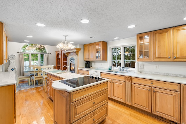 11 Bayside Dr, Wales, MA 01081 - kitchen featuring black electric stovetop, a kitchen island with sink, a textured ceiling, plenty of natural light, and glass insert cabinets