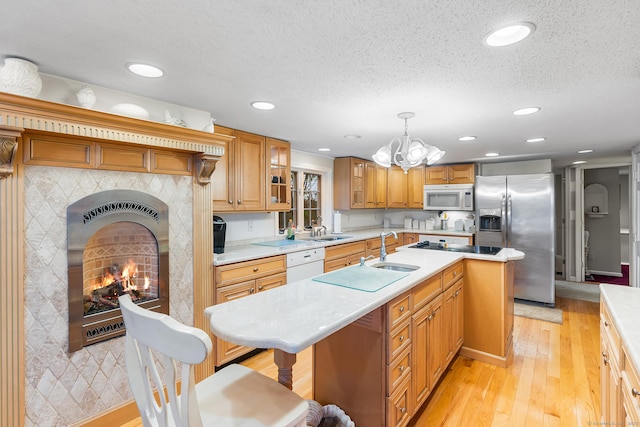 11 Bayside Dr, Wales, MA 01081 - kitchen featuring white appliances, light countertops, a center island with sink, light wood-type flooring, and glass insert cabinets