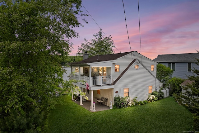 11 Bayside Dr, Wales, MA 01081 - back of property featuring a balcony, a lawn, a chimney, and a patio area