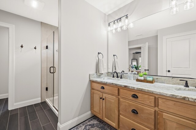 261 W St, Hebron, CT 06248 - bathroom with double vanity, a shower stall, and wood tiled floors