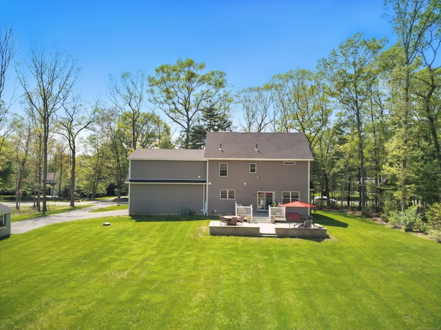 261 W St, Hebron, CT 06248 - back of property featuring a lawn, a wooden deck, and a patio