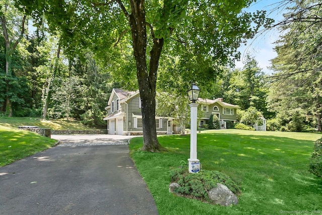 20 Aspen Mill Rd, Ridgefield, CT 06877 - view of front of house with asphalt driveway, a garage, and a front yard