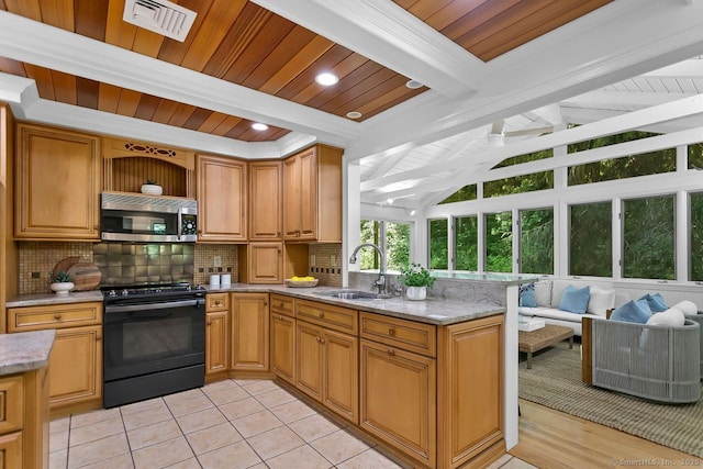 20 Aspen Mill Rd, Ridgefield, CT 06877 - kitchen with black range with electric cooktop, stainless steel microwave, decorative backsplash, a peninsula, and light stone countertops