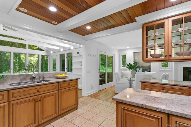 20 Aspen Mill Rd, Ridgefield, CT 06877 - kitchen featuring light tile patterned flooring, light stone counters, brown cabinets, glass insert cabinets, and recessed lighting
