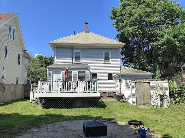 463 Washington Ave, West Haven, CT 06516 - back of property featuring a fire pit, a deck, a chimney, a storage shed, and a shingled roof