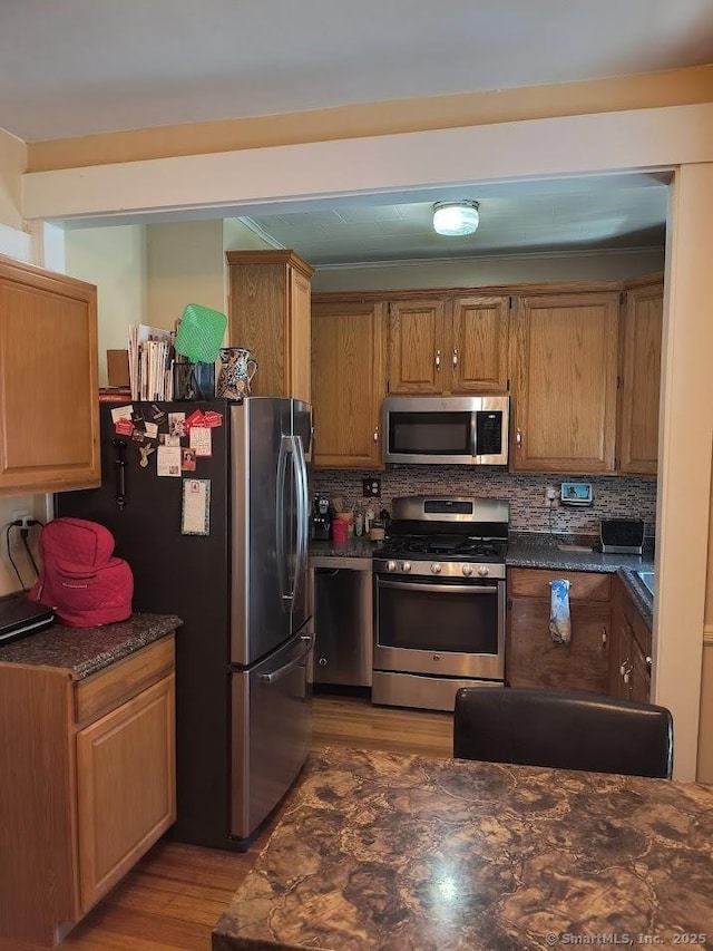 463 Washington Ave, West Haven, CT 06516 - kitchen featuring appliances with stainless steel finishes, dark countertops, wood finished floors, and backsplash