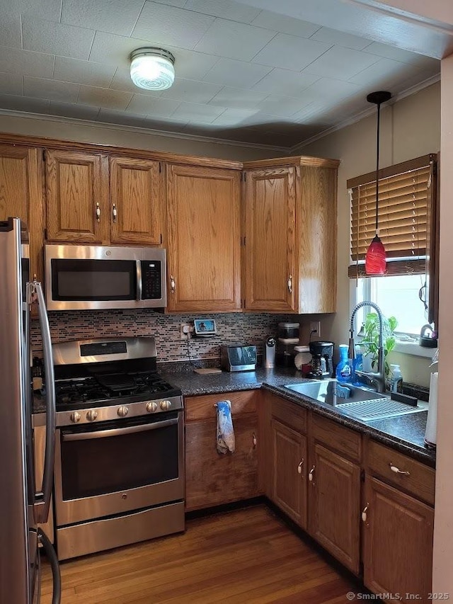 463 Washington Ave, West Haven, CT 06516 - kitchen with stainless steel appliances, ornamental molding, brown cabinets, tasteful backsplash, and dark wood-type flooring
