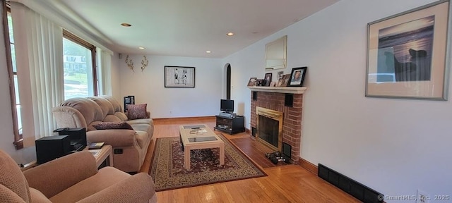 4 Clyne Ave, Waterbury, CT 06705 - living room with a fireplace, light wood-type flooring, arched walkways, and recessed lighting