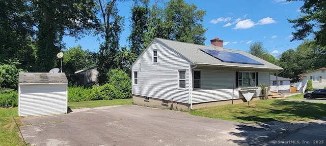 4 Clyne Ave, Waterbury, CT 06705 - view of home's exterior featuring solar panels, a chimney, a storage shed, and a yard