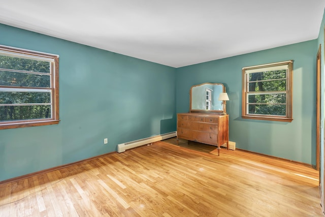 49 Nutmeg Ln, Shelton, CT 06484 - unfurnished bedroom with a baseboard heating unit, multiple windows, and wood finished floors