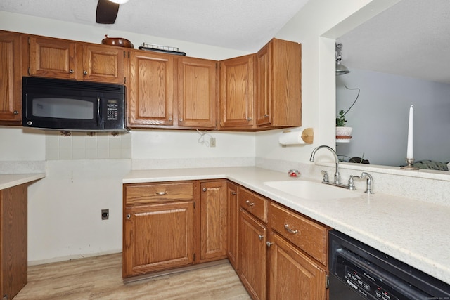 187 Lovers Ln Unit 4, Torrington, CT 06790 - kitchen featuring black appliances, light wood finished floors, brown cabinetry, and light countertops