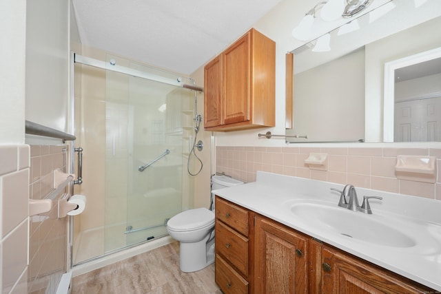 187 Lovers Ln Unit 4, Torrington, CT 06790 - bathroom featuring vanity, a stall shower, tile walls, and wood finished floors