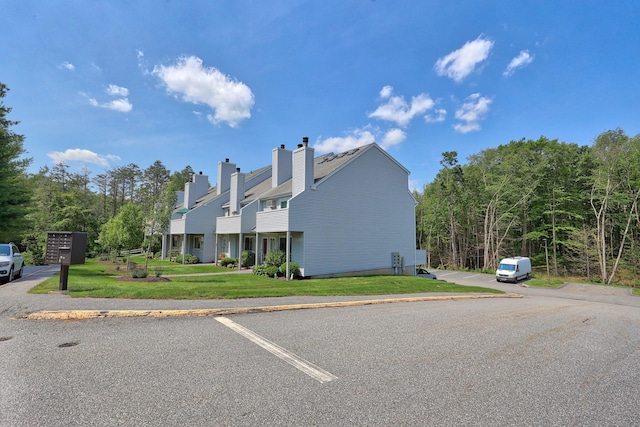 187 Lovers Ln Unit 4, Torrington, CT 06790 - view of side of property with a yard, a chimney, and uncovered parking