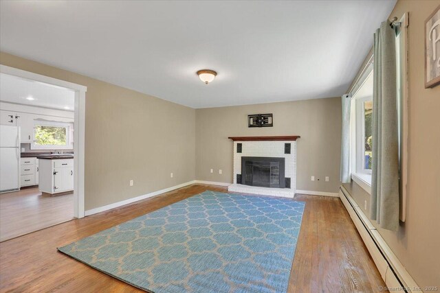 57 Lakeview Hts, Lebanon, CT 06249 - living area featuring a baseboard heating unit, wood finished floors, and a fireplace