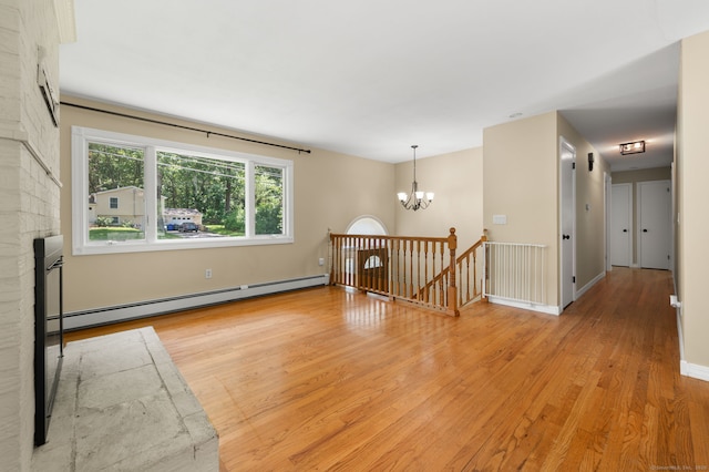 41 Laurel Leaf Dr, Ledyard, CT 06335 - empty room with a baseboard radiator, light wood-style flooring, and a chandelier