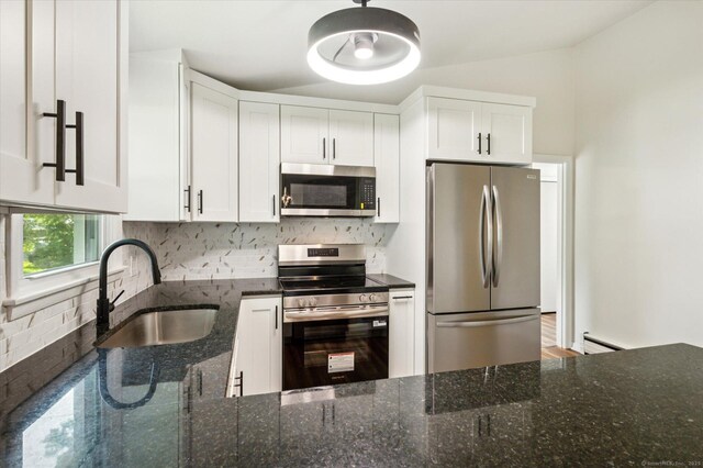 75 Atwood Hts, Thomaston, CT 06787 - kitchen with appliances with stainless steel finishes, decorative backsplash, dark stone counters, a baseboard heating unit, and white cabinetry