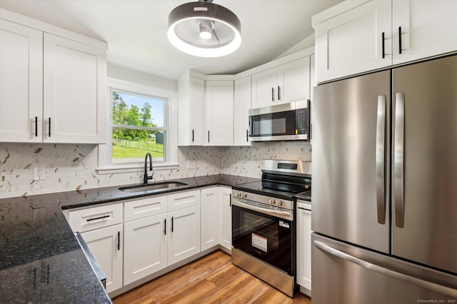 75 Atwood Hts, Thomaston, CT 06787 - kitchen with stainless steel appliances, white cabinetry, decorative backsplash, light wood-style flooring, and dark stone countertops