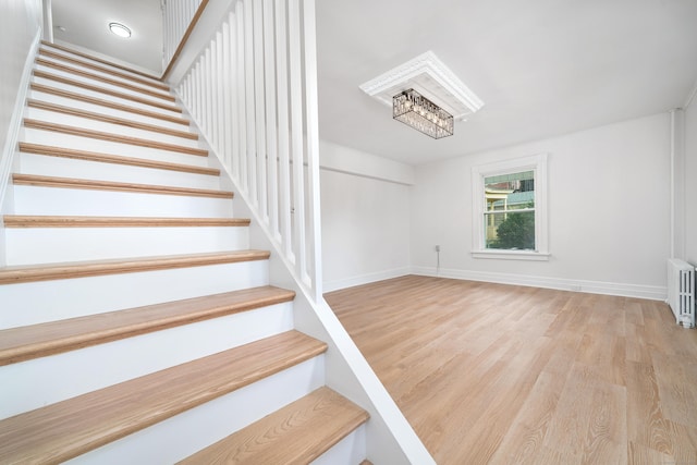 105 High St, Sprague, CT 06330 - staircase with wood finished floors, a chandelier, and radiator