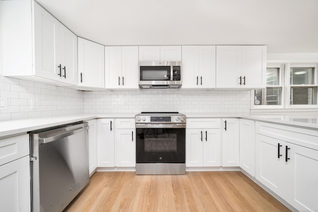 105 High St, Sprague, CT 06330 - kitchen featuring appliances with stainless steel finishes, light countertops, light wood finished floors, and white cabinets