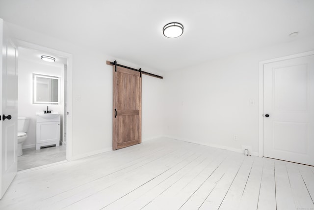 105 High St, Sprague, CT 06330 - unfurnished bedroom with a barn door, light wood-style floors, and ensuite bathroom