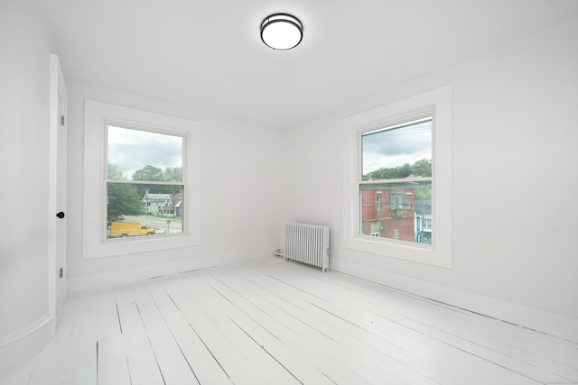105 High St, Sprague, CT 06330 - spare room featuring radiator heating unit, healthy amount of natural light, and wood finished floors