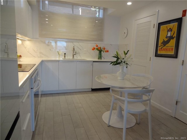 350 Grovers Ave Unit 11A, Bridgeport, CT 06605 - kitchen with dishwashing machine, white cabinets, light countertops, tasteful backsplash, and recessed lighting