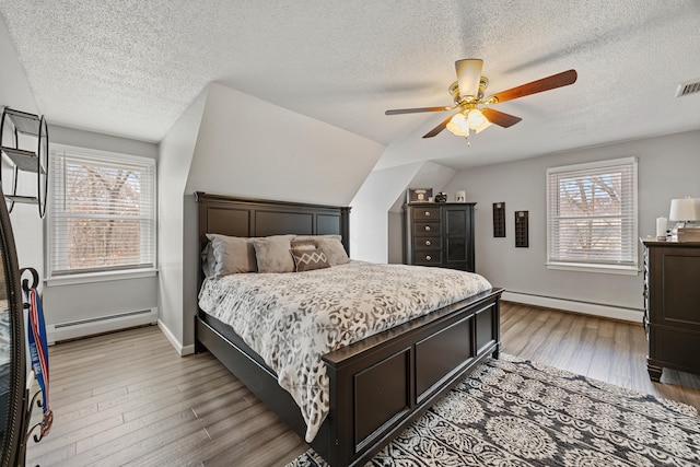 10 Heritage Dr, Prospect, CT 06712 - bedroom with a baseboard radiator, multiple windows, a textured ceiling, and wood finished floors