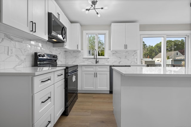 15 Burdette Pl, Milford, CT 06460 - kitchen with stainless steel appliances, decorative backsplash, white cabinets, and light wood-type flooring