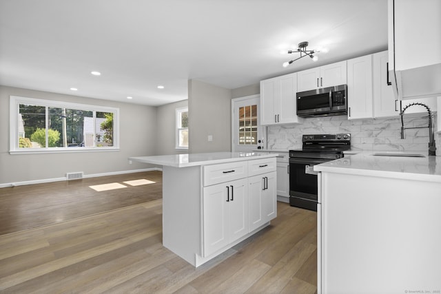 15 Burdette Pl, Milford, CT 06460 - kitchen featuring stainless steel microwave, black electric range oven, light wood-style flooring, tasteful backsplash, and recessed lighting