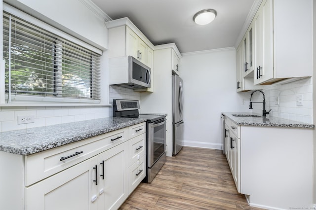 4 Union Ave Apt 23, Norwalk, CT 06851 - kitchen featuring appliances with stainless steel finishes, tasteful backsplash, ornamental molding, light stone countertops, and wood finished floors