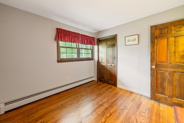 6 Revere Rd, New Milford, CT 06776 - unfurnished bedroom featuring a baseboard heating unit, light wood-type flooring, and a closet