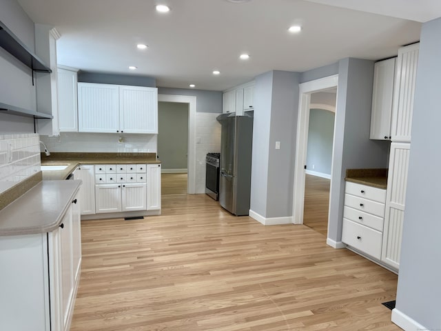 654 Nichols Ave, Stratford, CT 06614 - kitchen with stainless steel appliances, backsplash, white cabinetry, light wood-type flooring, and recessed lighting