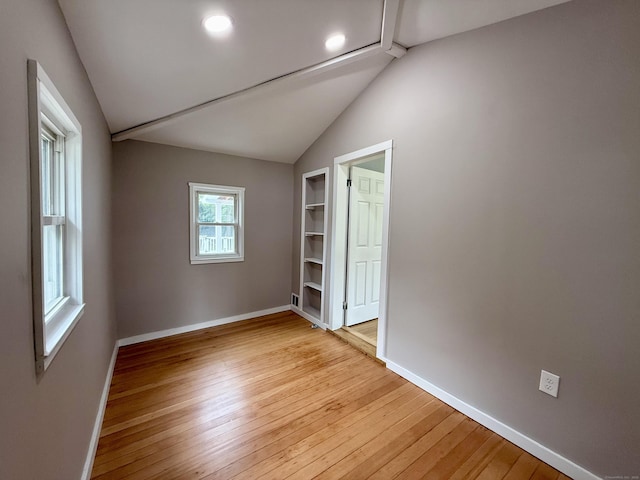 654 Nichols Ave, Stratford, CT 06614 - empty room featuring lofted ceiling, light wood-style flooring, built in shelves, and recessed lighting