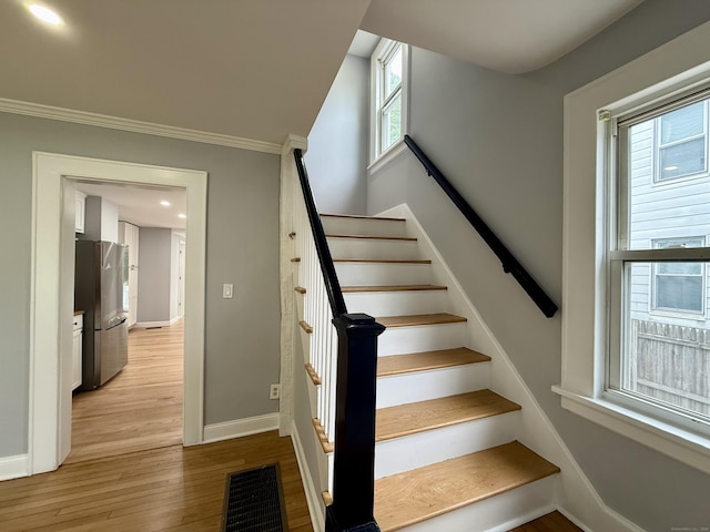 654 Nichols Ave, Stratford, CT 06614 - staircase featuring plenty of natural light, ornamental molding, and wood finished floors