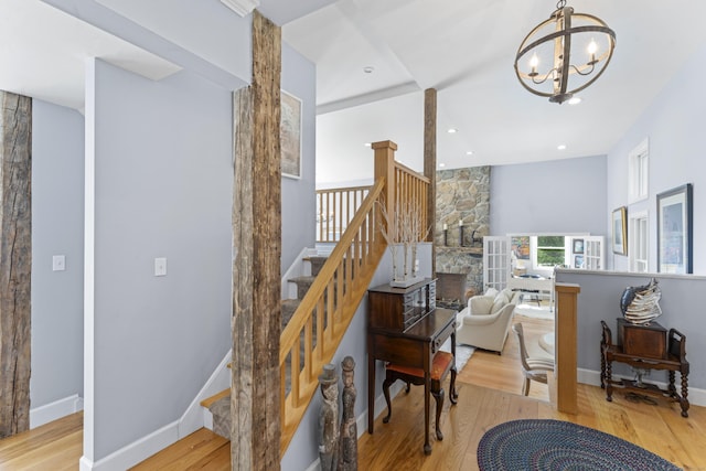 168 Cobble Rd, Kent, CT 06757 - stairs featuring wood finished floors, a chandelier, recessed lighting, and a stone fireplace