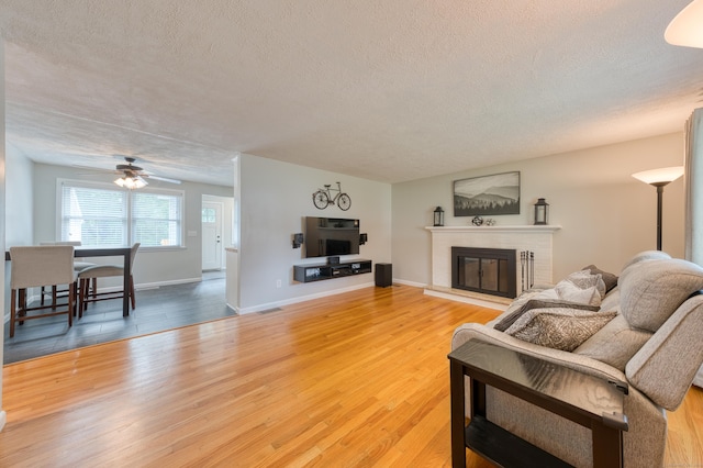 226 Farm Hill Rd, Middletown, CT 06457 - living room with a textured ceiling, a ceiling fan, a brick fireplace, and light wood finished floors